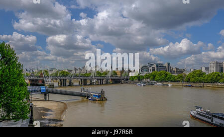 Londra Tamigi vista guardando verso Hungerford ponte ferroviario. Mostra le navi e il Festival Pier. Foto Stock