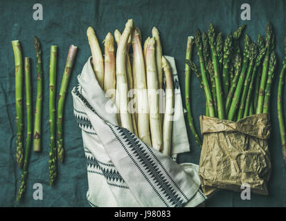 Fresco verde e asparagi bianchi in asciugamano e sfondo grigio Foto Stock