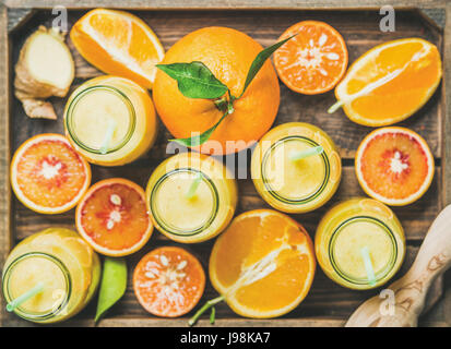 Un sano frullato giallo in bottiglie con frutta fresca nel vassoio Foto Stock