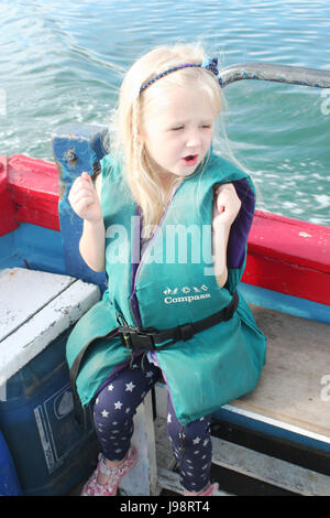 Bambino di indossare un giubbotto di salvataggio,avendo divertimento su un viaggio in barca nella baia di Dublino, Irlanda Foto Stock