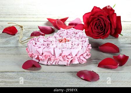 Cuore della carta ed una rosa rossa su sfondo di legno Foto Stock