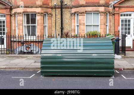 Metallo verde bike sparso nella parte anteriore di una casa vittoriana su un Street a Londra, Regno Unito. Foto Stock