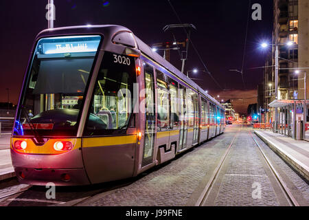 Tram Luas light railway a Dublino di notte, l'Irlanda, che porta oltre trenta milioni di persone ogni anno. Foto Stock