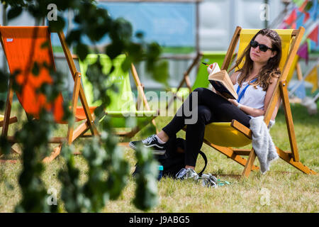 Festival di fieno, Hay on Wye, Wales, Regno Unito. Dal 01 Giugno, 2017. Regno Unito Meteo: una giovane donna di relax con un libro seduto in una sedia a sdraio, godendo la multa caldo e soleggiato su 1 giugno, il primo giorno di estate meteorologica al 2017 Hay Festival, nella piccola cittadina gallese di Hay on Wye in rurale Powys. Oggi festeggia il suo trentesimo anno il festival della letteratura richiama alcuni dei migliori scrittori, docenti universitari e commentatori di tutto il mondo e decine di migliaia di visitatori al giorno a ciò che è stato descritto da ex presidente degli Stati Uniti Bill Clinton come 'Il Woodstock della mente' Credit: keith morris/Alamy Live News Foto Stock