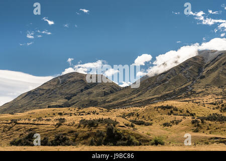 La Terra di Mezzo, Nuova Zelanda - 14 Marzo 2017: la gamma della montagna a terra centrale sotto il blu cielo nuvoloso. Alta scenario desertico con rada vegetazione marrone. Sh Foto Stock