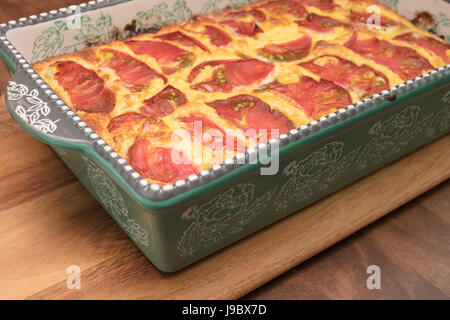 White melanzana, formaggio e pancetta cotta quiche con pomodoro guarnire Foto Stock