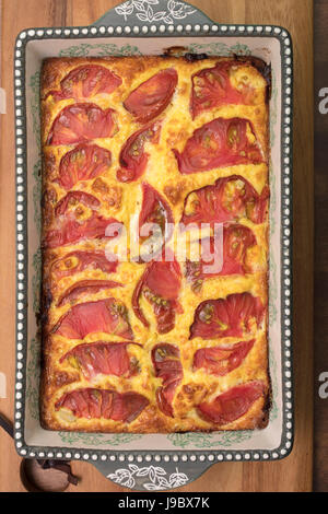 White melanzana, formaggio e pancetta cotta quiche con pomodoro guarnire Foto Stock