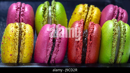 Close up di amaretti colorati su sfondo nero. Spazio per il testo. Foto Stock