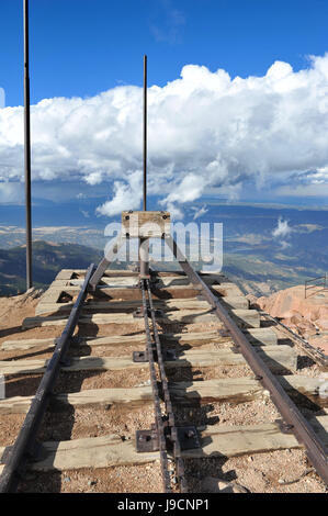 Binari del treno in cima Pikes Peak finire bruscamente in corrispondenza del bordo di una scogliera alta sopra la valle al di sotto di Foto Stock