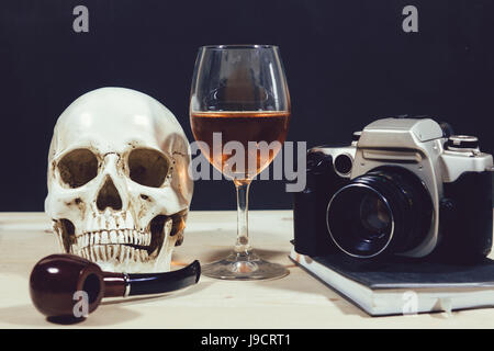 Testa cranio con tubo di fumo e vino redcamera Foto Stock