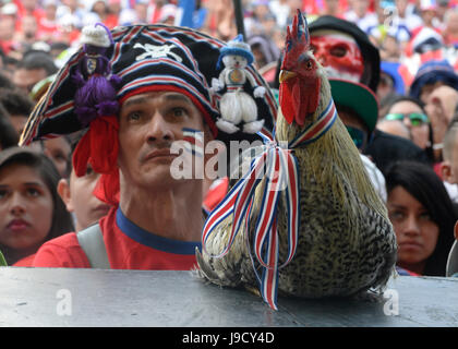 Una Costa Rica la ventola e il suo gallo pet stand in San José di Plaza de la Democracía per guardare la costa la squadra nazionale prendere sui Paesi Bassi nella quarte Foto Stock