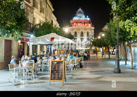 Vista notturna di caffetterie lungo la Calle Lanceria e El Gallo Azul rotunda edificio, Jerez de la Frontera, Andalusia, Spagna, Europa Foto Stock