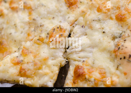 Serve una quattro formaggi pizza con formaggio fuso Foto Stock