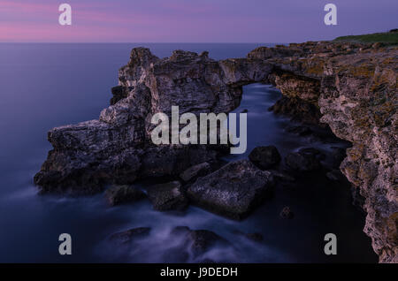 Bellissimo tramonto sul mare e arco di roccia Foto Stock