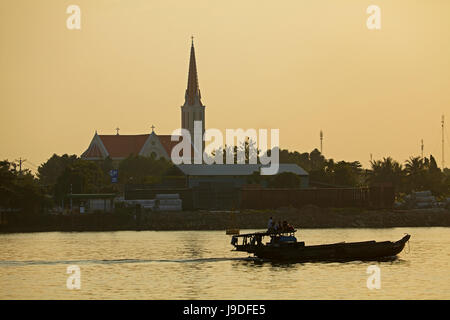Barca sul Co Chien Fiume (ramo del fiume Mekong) e silhouette di chiesa, Vinh Long, Delta del Mekong, Vietnam Foto Stock