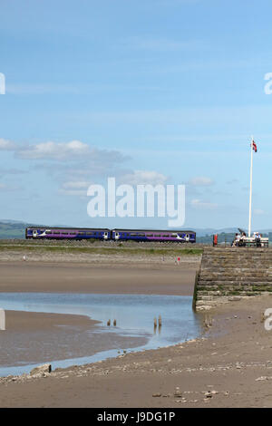 Classe 156 super sprinter dmu azionato da Nord a Arnside sulla linea Furness lasciando Arnside viadotto con Arnside Pier in primo piano. Foto Stock