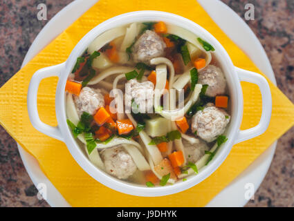 Zuppa con polpette di carne e le tagliatelle in una piastra bianca Foto Stock