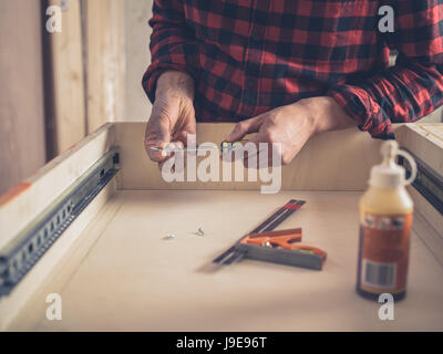 Un falegname è la costruzione di un cassetto nella sua officina Foto Stock