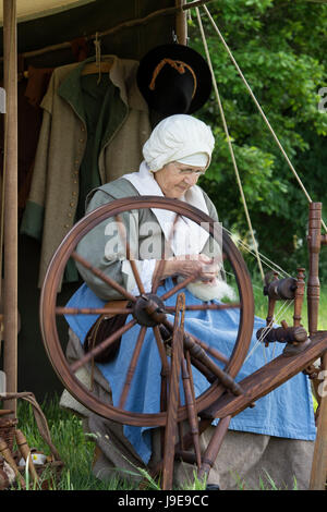 La donna la filatura in un accampamento presso un Nodo sigillato guerra civile inglese rievocazione storica evento. Charlton Park di Malmesbury, Wiltshire, Regno Unito Foto Stock