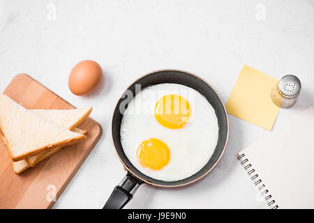 Vista superiore della tradizionale facile sana colazione veloce pasto fatto di uova fritte servite su una padella. Foto Stock