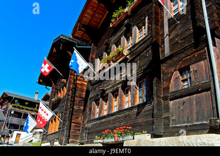 Chalet Svizzero con le bandiere del paese, il cantone e il comune, Blatten, Lötschental, Vallese, Svizzera Foto Stock