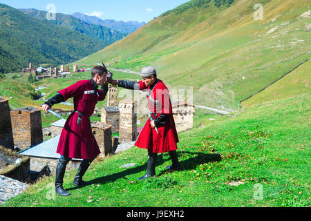 Il pugnale di spettacolo di combattimento da due uomini georgiano di un gruppo folcloristico, Ushguli, regione di Svaneti, Georgia Foto Stock