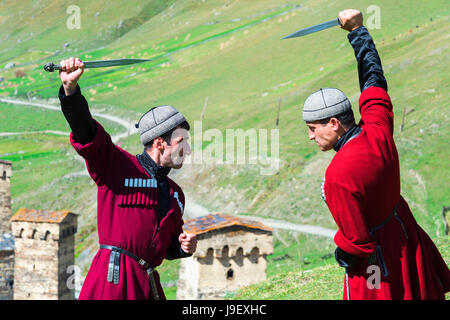 Il pugnale di spettacolo di combattimento da due uomini georgiano di un gruppo folcloristico, Ushguli, regione di Svaneti, Georgia Foto Stock