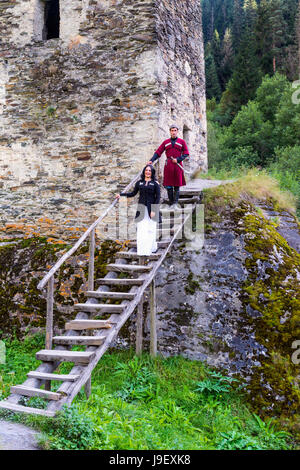 Georgian giovane in abito tradizionale scendendo le scale in legno dalla torre di amore, per il solo uso editoriale, Ushguli, regione di Svaneti, Georgia Foto Stock