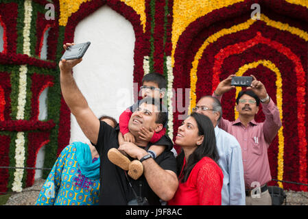 Un padre prende un selfie di se stesso e la sua famiglia nella Lal Bagh Giardini Botanici Bengalaru, Karnataka, India Foto Stock