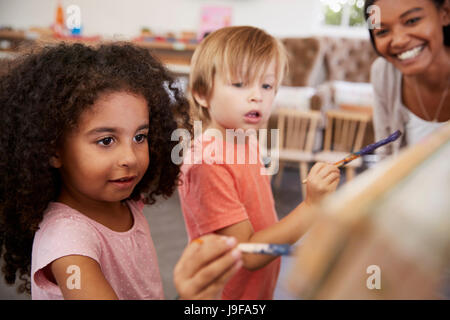 Docente presso la Scuola Montessori aiutando i bambini in classe D'ARTE Foto Stock