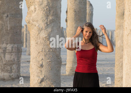 Bella donna divertendosi intorno al vecchio bandoned costruzioni in calcestruzzo Pilastri. Foto Stock