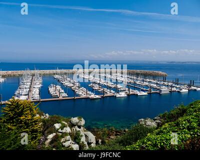 Imbarcazioni da diporto nel Porto di Port du Blascon con granito jetty e Baia di Morlaix in background. Roscoff, Brittany, Francia. Foto Stock