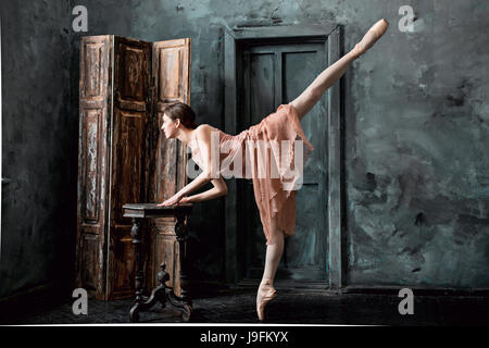 Giovane e incredibilmente bella ballerina è in posa e balli in un studio di nero Foto Stock