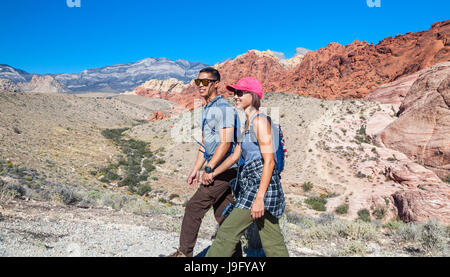 Coppia con arrampicata su roccia marcia escursione al Red Rock Canyon National Conservation Area, che si trova a circa 20 miglia dal Las Vegas Foto Stock