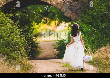 Bella ragazza in abito bianco entrare nel bosco Foto Stock