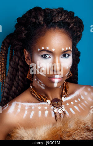 Stile africano donna . Attraente giovane donna in gioielli etnici . close up ritratto di una donna con una faccia dipinta. Trucco creativo e stile luminoso. Foto Stock