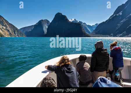 I turisti su una barca ammirando la bellezza di Milford Sound Fiordland, Nuova Zelanda Foto Stock