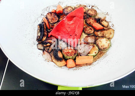 Friggere le zucchine, carote, funghi e pepe rosso con salsa di soia e caldo di olio di semi di girasole in un wok Foto Stock