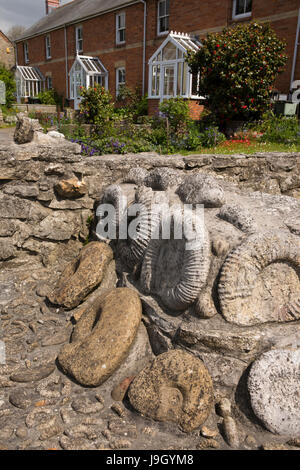 Regno Unito Inghilterra, Dorset, Portesham, Front Street, ammonita decorazione fossili nel giardino antistante parete Foto Stock