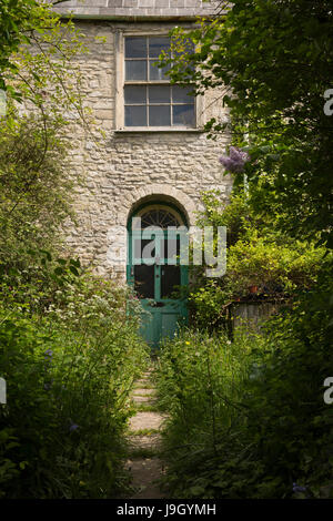 Regno Unito Inghilterra, Dorset, Portesham, Front Street, vecchia casa abbandonata la porta anteriore incolto giardino Foto Stock