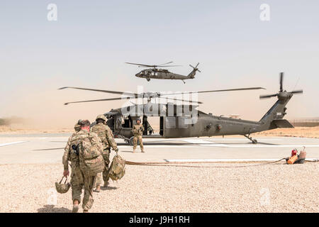 Un U.S. Esercito UH-60 Black Hawk elicottero capo equipaggio assegnati alla Task Force Griffin, xvi combattere la Brigata Aerea, dirige i passeggeri durante il caricamento di Maggio 31, 2017 a Kunduz, Afghanistan. Kunduz ha visto aumentare la attività dei Talebani come più di 8.000 soldati americani e 6.000 dalla NATO e i paesi alleati di continuare ad assistere il governo. Foto Stock