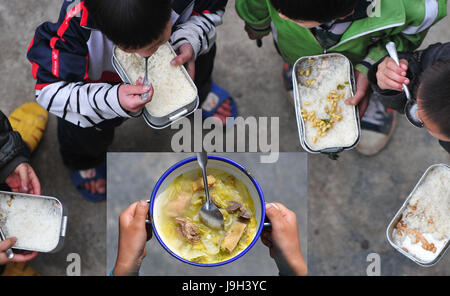 (170602) -- NANNING, Giugno 2, 2017 (Xinhua) -- combinati foto mostra un bambino prendendo un pasto di pollo il 7 maggio 2017 (fondo) e o mostra i bambini a mangiare semi di soia semi di riso per il pranzo a scuola il 24 marzo 2011 a un rurale la scuola primaria in Hechi City, a sud della Cina di Guangxi Zhuang Regione autonoma. I bambini che vivono in miseria, regione montuosa nel Guangxi hanno testimoniato la loro vita girare nuovo di zecca negli ultimi sette anni, con i loro bisogni fondamentali per la vita e la scuola soddisfatto grazie alla riduzione della povertà gli sforzi del governo locale. Liscia strade rurali e nutriente e pranzo a scuola sono diventati nuovo m Foto Stock