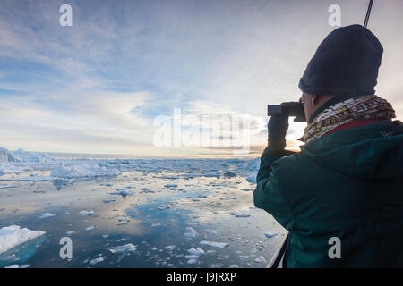 La Groenlandia, Disko Bay, Ilulissat, a bordo di barche da pesca nel ghiaccio flaoting, tramonto Foto Stock