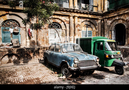 Antica India conservati in questo grintoso backstreet immagine del cortile in zona residenziale e unici due veicoli parcheggiati in mezzo storico di decadimento di frantumazione Foto Stock