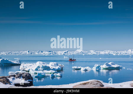 La Groenlandia, Disko Bay, Oqaatsut, ghiaccio galleggiante e la piccola barca Foto Stock