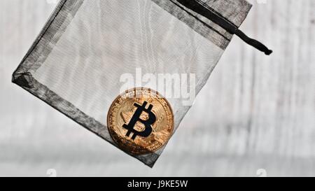 Valuta digitale oro fisico bitcoin coin in borsa nera. Foto Stock