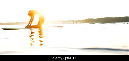 Donna fare yoga su un SUP Foto Stock