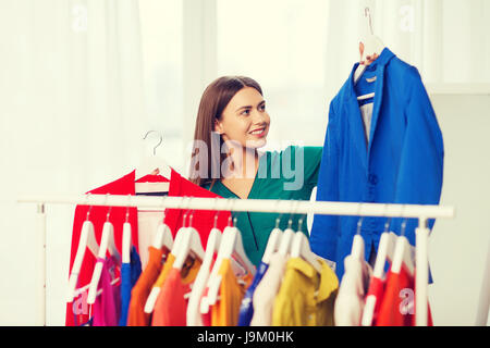 Donna felice la scelta di vestiti a casa guardaroba Foto Stock