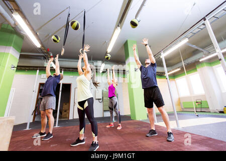 Gruppo di persone con la palla medica formazione in palestra Foto Stock