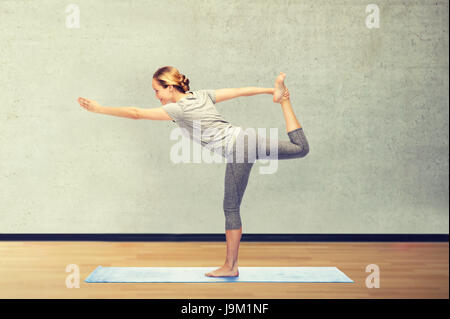 Donna fare yoga nel Signore della danza pone sul tappeto Foto Stock